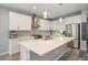 Modern kitchen with white cabinets, stainless steel appliances, an expansive island, and stylish pendant lighting at 8948 Delacorte St, Highlands Ranch, CO 80129