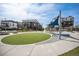 Exterior view of a community playground with modern play equipment and a soft turf area, surrounded by stylish townhomes at 8948 Delacorte St, Littleton, CO 80129