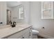 Clean half bathroom with white cabinets, quartz countertop and a sleek sink at 8644 Pennycress Dr, Littleton, CO 80125