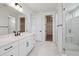 A modern bathroom with black hardware, white cabinets, glass shower, and dual sinks at 8644 Pennycress Dr, Littleton, CO 80125