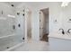 A modern bathroom with black hardware, white marbled floors, glass shower, and dual sinks at 8644 Pennycress Dr, Littleton, CO 80125