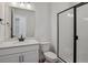 Well-lit bathroom features black hardware, a white vanity, a toilet, and a glass enclosed shower at 8644 Pennycress Dr, Littleton, CO 80125
