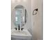 Half bathroom with an oval mirror, modern fixtures, and neutral tones at 8644 Pennycress Dr, Littleton, CO 80125