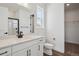 A bright bathroom with black hardware, white cabinets, and a black framed shower at 8644 Pennycress Dr, Littleton, CO 80125