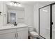 Modern bathroom featuring white cabinets, quartz countertops, a shower, and a large mirror at 8644 Pennycress Dr, Littleton, CO 80125