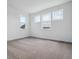 Bright bedroom with neutral carpet and white walls is naturally lit from three windows at 8644 Pennycress Dr, Littleton, CO 80125