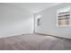 Bright bedroom with neutral carpet and white walls is naturally lit from two windows at 8644 Pennycress Dr, Littleton, CO 80125