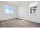 Bright bedroom featuring neutral carpet, white walls and trim, and large windows at 8644 Pennycress Dr, Littleton, CO 80125