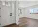 Inviting entryway featuring a modern white door, light-filled room, and elegant hard wood flooring at 8644 Pennycress Dr, Littleton, CO 80125