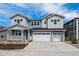 Charming two-story home with well-manicured landscaping and a three-car garage and inviting front porch at 8644 Pennycress Dr, Littleton, CO 80125