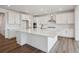 Modern kitchen with white cabinets, stainless steel range hood, and large island with seating at 8644 Pennycress Dr, Littleton, CO 80125