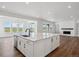 Bright kitchen features white cabinets, stainless steel appliances, and an island with a quartz countertop at 8644 Pennycress Dr, Littleton, CO 80125