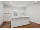Bright kitchen featuring white cabinets and island with countertop and wood-look floors at 8644 Pennycress Dr, Littleton, CO 80125