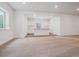 Spacious living room boasts neutral carpet, large window, and dry bar area with cabinets at 8644 Pennycress Dr, Littleton, CO 80125