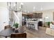 Open-concept kitchen with stainless steel appliances, island with stools, and modern chandelier at 1356 S Boston Ct # A, Denver, CO 80247