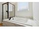 Modern bathroom with a white bathtub, a shower stall with glass door, and marble-like walls at 42998 Colonial Trl, Elizabeth, CO 80107