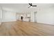 Open-concept living room with hardwood floors, white walls, ceiling fan, and kitchen view at 42998 Colonial Trl, Elizabeth, CO 80107