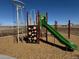 Community playground with climbing structure, green slide, and wood chip ground cover at 42998 Colonial Trl, Elizabeth, CO 80107