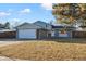 Ranch style home with a gray exterior, attached garage, and well-maintained lawn at 6675 S Apache Dr, Littleton, CO 80120