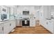 Updated kitchen featuring white cabinets, stainless steel appliances, and quartz countertops at 6675 S Apache Dr, Littleton, CO 80120