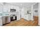 Modern kitchen with white cabinets, stainless steel appliances, and a breakfast bar at 6675 S Apache Dr, Littleton, CO 80120