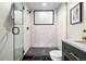 Modern bathroom with a glass-enclosed shower, black fixtures and unique tile work at 1308 Stuart St, Denver, CO 80204