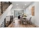 Open-concept dining area with a modern table set, adjacent to a stylish staircase and living room at 1308 Stuart St, Denver, CO 80204