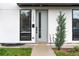 Close-up of modern front door with sleek design, vertical window, and tidy landscaping creating curb appeal at 1308 Stuart St, Denver, CO 80204