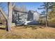 View of the backyard and exterior of this two-story home with a gray privacy fence and mature trees at 780 Utica Ave, Boulder, CO 80304