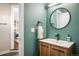 Stylish powder room with modern fixtures, vanity with wood cabinet, and a unique round mirror at 780 Utica Ave, Boulder, CO 80304