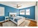 Bright bedroom with blue walls, hardwood floors, ceiling fan and a large window providing natural light at 780 Utica Ave, Boulder, CO 80304