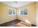 Sunlit bedroom with hardwood floors and ample natural light from two large windows at 780 Utica Ave, Boulder, CO 80304