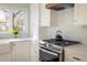 Bright kitchen featuring stainless steel range, farmhouse sink, mosaic tile backsplash, and abundant natural light at 780 Utica Ave, Boulder, CO 80304