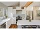 Bright kitchen with white cabinets, stainless steel appliances, a farmhouse sink and an island with counter seating at 780 Utica Ave, Boulder, CO 80304