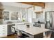 Bright kitchen with wood beams, stainless steel appliances, mosaic tile backsplash, and center island with seating at 780 Utica Ave, Boulder, CO 80304