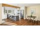 Sun-drenched kitchen with island seating, stainless appliances, wood beam, open to dining area with hardwood floors at 780 Utica Ave, Boulder, CO 80304