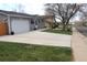 Single story house with a concrete driveway, green lawn, and gray siding at 19038 E Girard Ave, Aurora, CO 80013