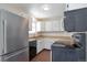 Kitchen featuring white cabinets, light countertops, and stainless steel refrigerator and stove at 19038 E Girard Ave, Aurora, CO 80013