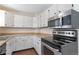 Kitchen with white cabinets, laminate countertops, and stainless steel appliances at 19038 E Girard Ave, Aurora, CO 80013