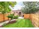 Well-maintained backyard with healthy lawn, wooden fence, landscaping and access to the house at 3071 W 38Th Ave, Denver, CO 80211