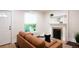 Cozy living room featuring a decorative fireplace, bright window, and comfortable seating at 3071 W 38Th Ave, Denver, CO 80211