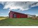 Large red barn with white trim and a spacious green lawn at 10232 Yampa Ct, Commerce City, CO 80022