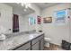Well-lit bathroom with a granite countertop, modern fixtures, and a shower with a curtain at 10232 Yampa Ct, Commerce City, CO 80022
