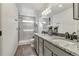 Bathroom showcasing double sinks, granite countertops, and a glass shower at 10232 Yampa Ct, Commerce City, CO 80022