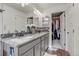 Bathroom with dual granite countertop vanity and view into the walk-in closet at 10232 Yampa Ct, Commerce City, CO 80022