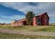 Exterior of a red barn-style building with a tree in front and a gravel path at 10232 Yampa Ct, Commerce City, CO 80022