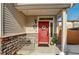 Charming front porch with a bright red door, stone accents, and seasonal decorations at 10232 Yampa Ct, Commerce City, CO 80022