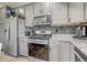 Modern kitchen with stainless steel appliances, gray cabinets and granite counters at 10232 Yampa Ct, Commerce City, CO 80022