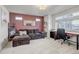 Comfortable living room with ample seating, a desk area, and natural light from a large window at 10232 Yampa Ct, Commerce City, CO 80022