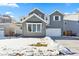 Two-story house with gray siding, white garage door, and snowy front yard at 9349 Russell Cir, Arvada, CO 80007